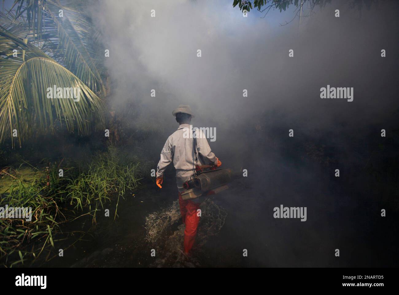A Thai health worker wades through floodwaters as he fumigates a flooded neighborhood on the outskirts of Bangkok,Thailand, Friday, Nov. 25, 2011. Since July, more than a fifth of the country's 64 million people have been affected by the worst flooding in more than 50 years. (AP Photo/Altaf Qadri) Stockfoto