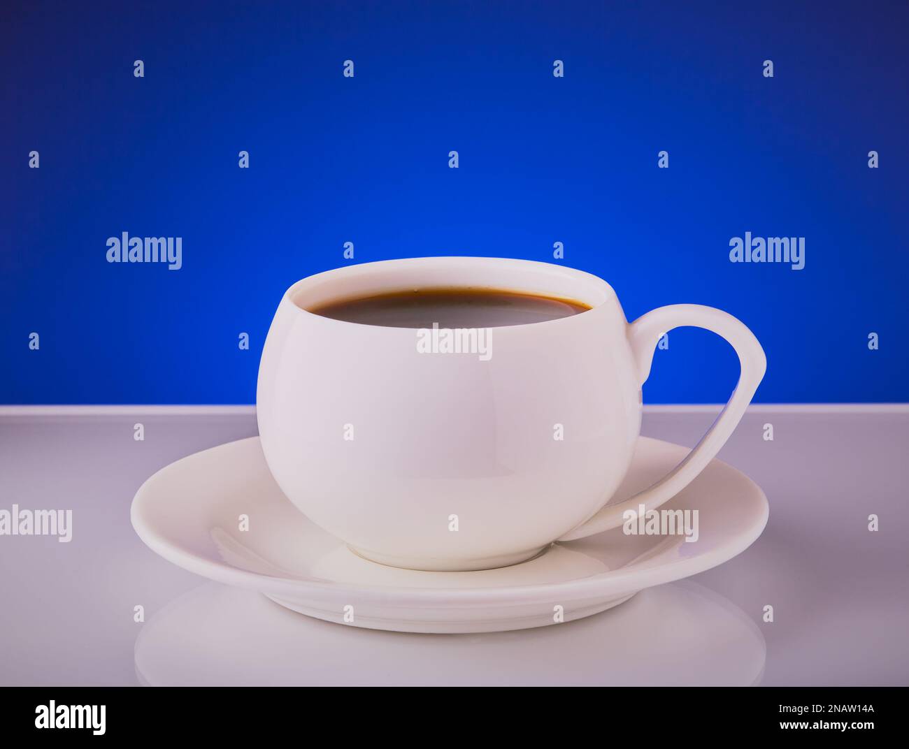 Tasse Kaffee in einer weißen Tasse auf blauem Hintergrund. Stockfoto