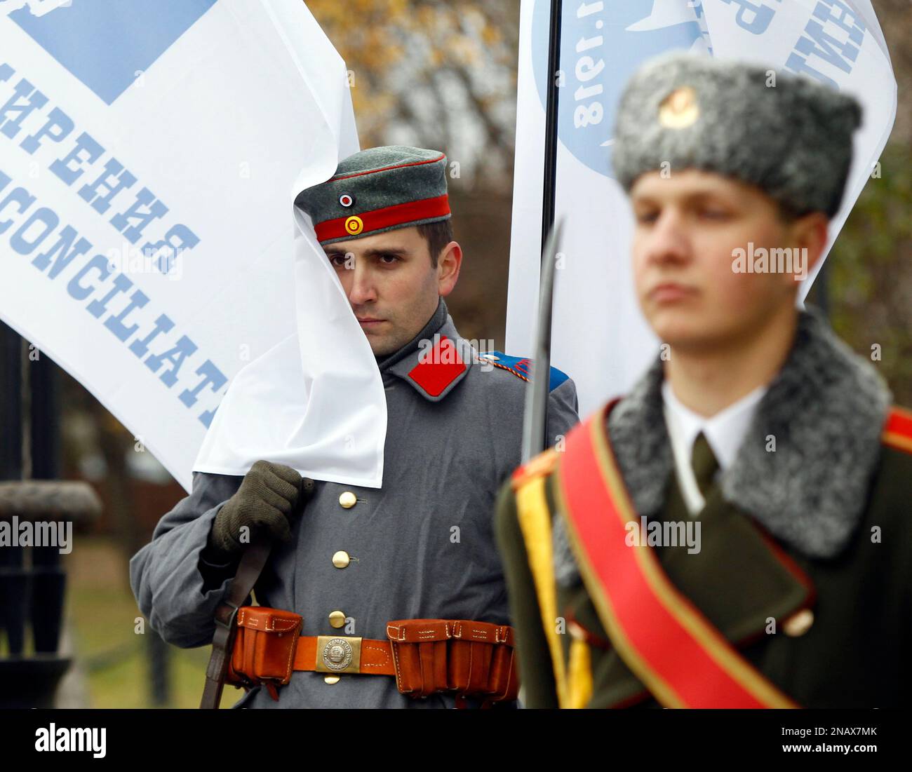 A re-enactor dressed as an 1914 German soldier, left, and a Belarusian honor guard attend the Reconciliation Day ceremony on a military cemetery where thousands of soldiers were buried after World War I battles, in Minsk, Belarus, on Friday, Nov. 11, 2011 . On November 11, 1918, fighting in World War I came to an end with the signing of an armistice between the Allies and Germany. Writing on flag left reads " Day of Reconciliation." (AP Photo/Sergei Grits) Stockfoto
