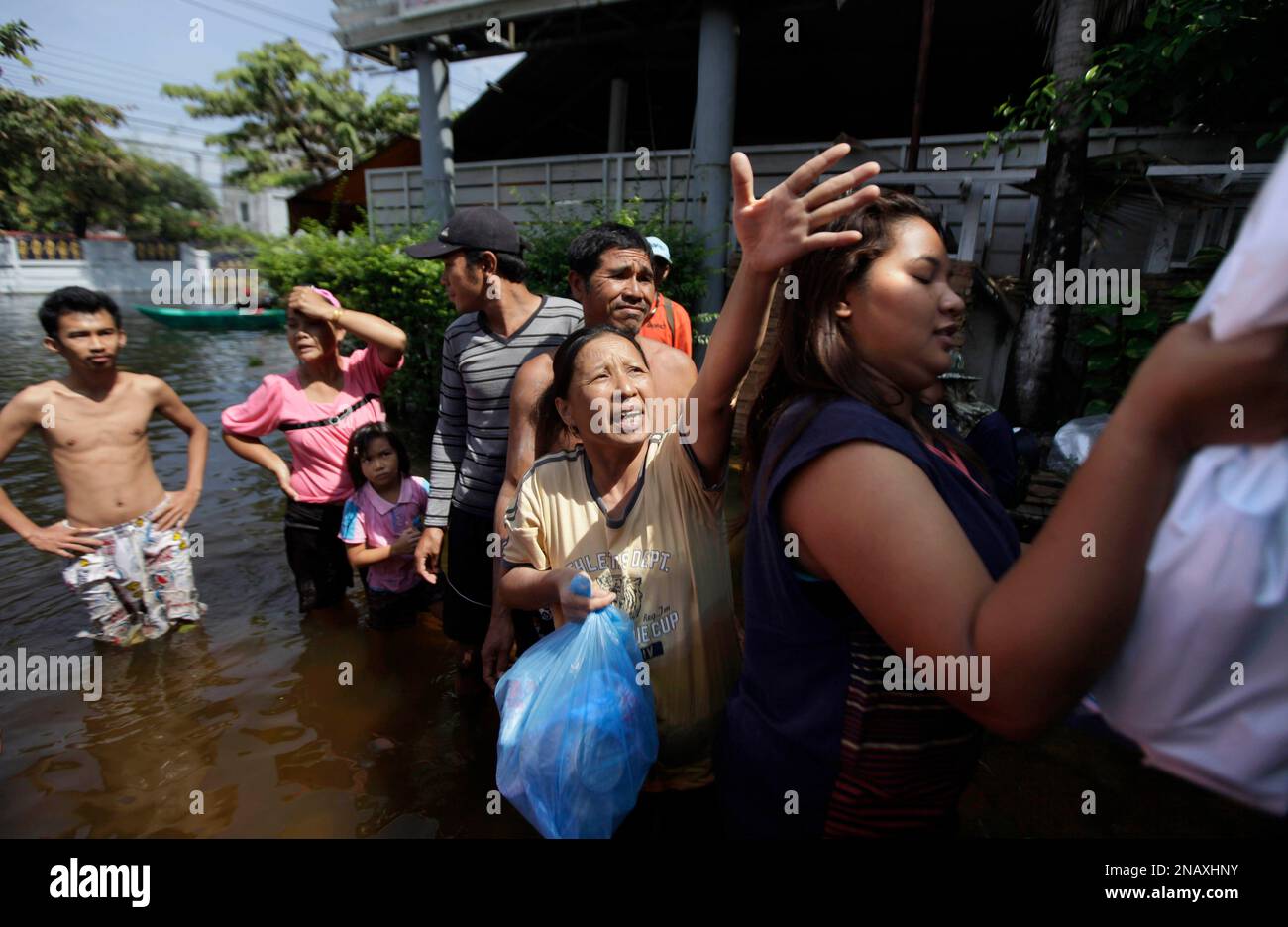 A Thai woman asks for food packets distributed from soldiers at a flooded neighborhood in Bangkok, Thailand, Wednesday, Nov. 9, 2011. The flooding began in late July and the water has reached parts of Bangkok, where residents are frustrated by government confusion over how much worse the flooding will get. (AP Photo/Altaf Qadri) Stockfoto