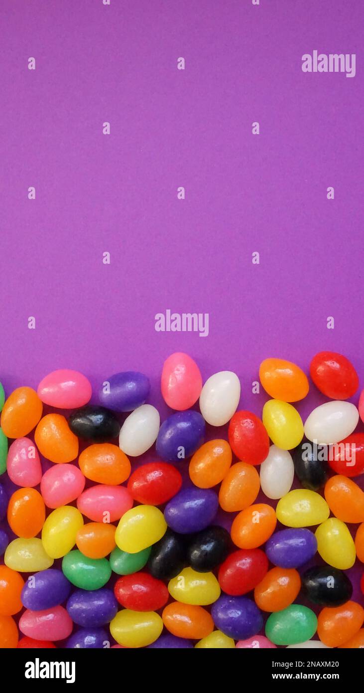 Farbenfrohe Jelly Beans auf lila Hintergrund zu Ostern. Stockfoto