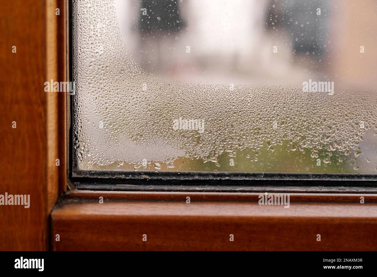 Feuchtigkeit in der Wohnung. Feuchten Sie das PVC-Fenster mit Tropfen Wasserkondensat an Stockfoto