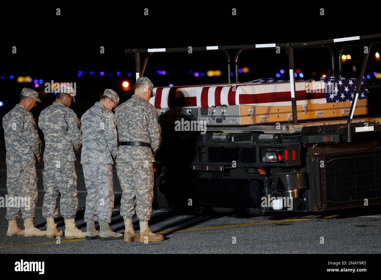 Chaplain Col. Scott H. Jensen, left, leads a prayer over the transfer cases containing the