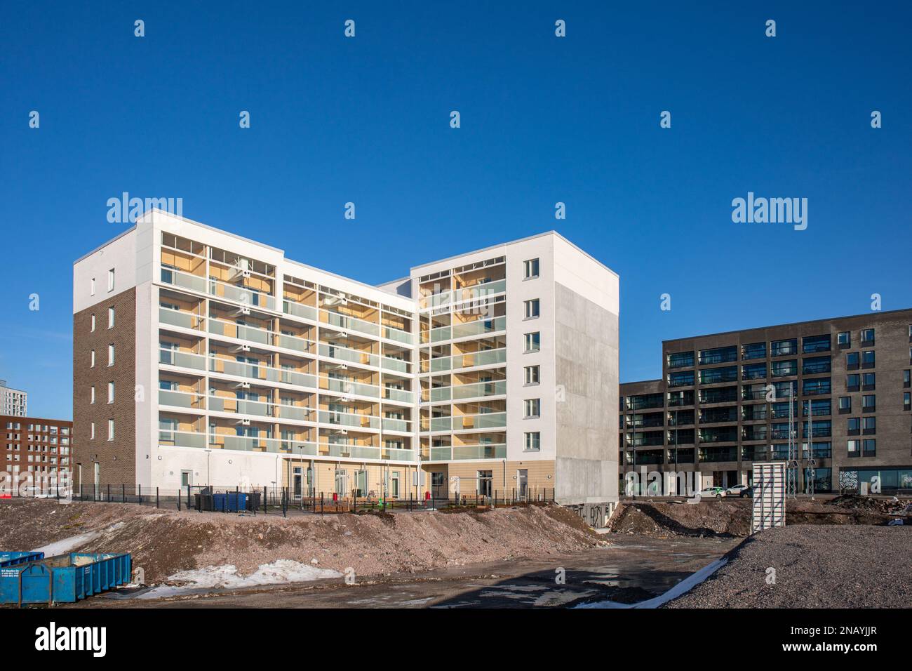 Leerstehender Parkplatz neben dem neu errichteten Wohngebäude in Atlantinkatu in Jätkäsaari oder Länsisatama in Helsinki, Finnland Stockfoto