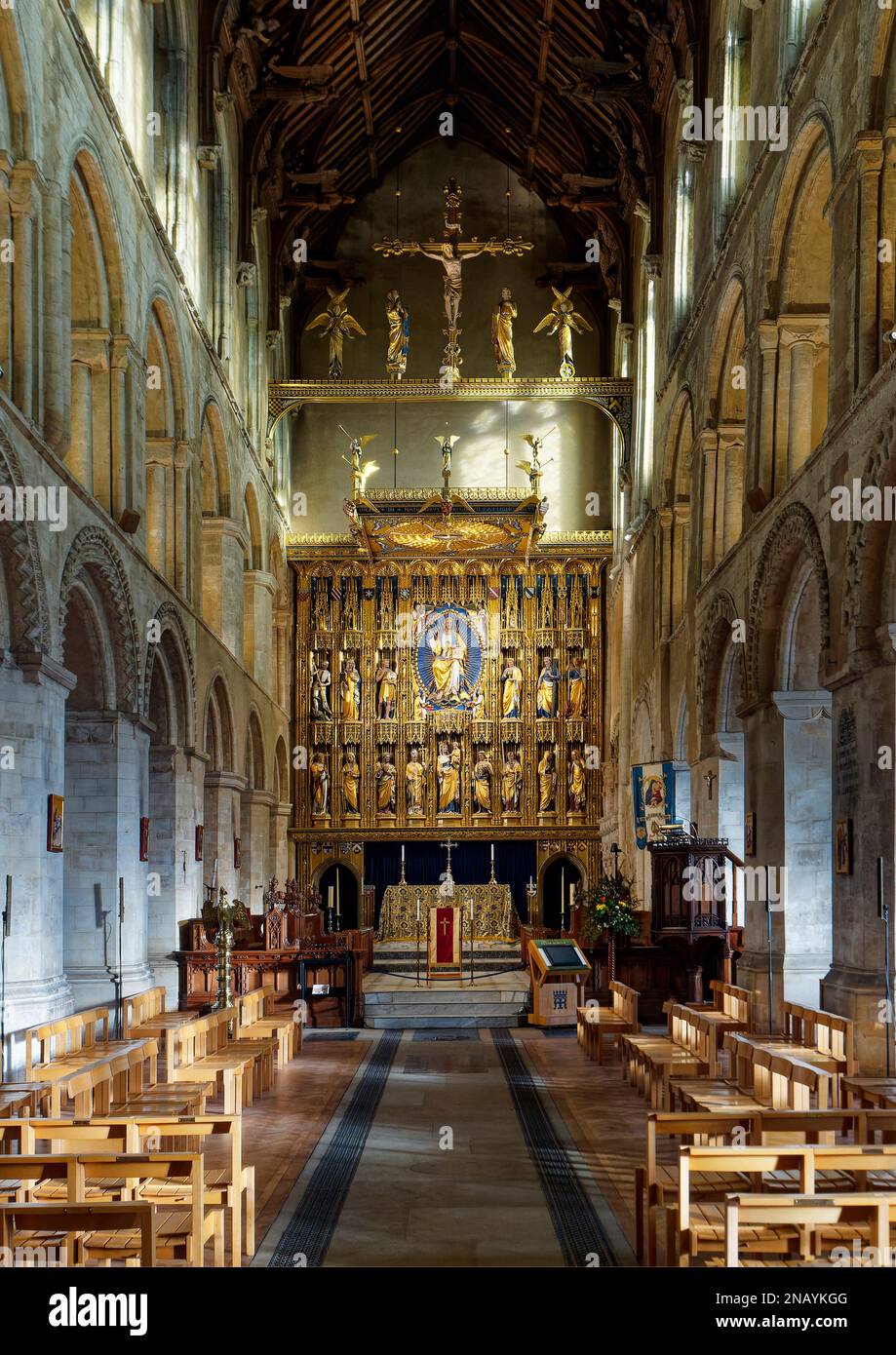 Das Schiff und der Chancel von Wymondham Abbey in Norfolk zeigen die normannische Architektur und die vergoldeten Reredos oder die Altarleinwand des Kriegsdenkmals von WW1. Stockfoto