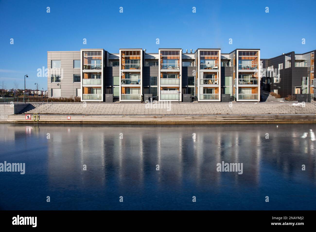 Saukonpaasi. Neu gebaute Wohngebäude am Ufer des gefrorenen alten Hafenbeckens in Jätkäsaari oder im Bezirk Länsisatama in Helsinki, Finnland. Stockfoto
