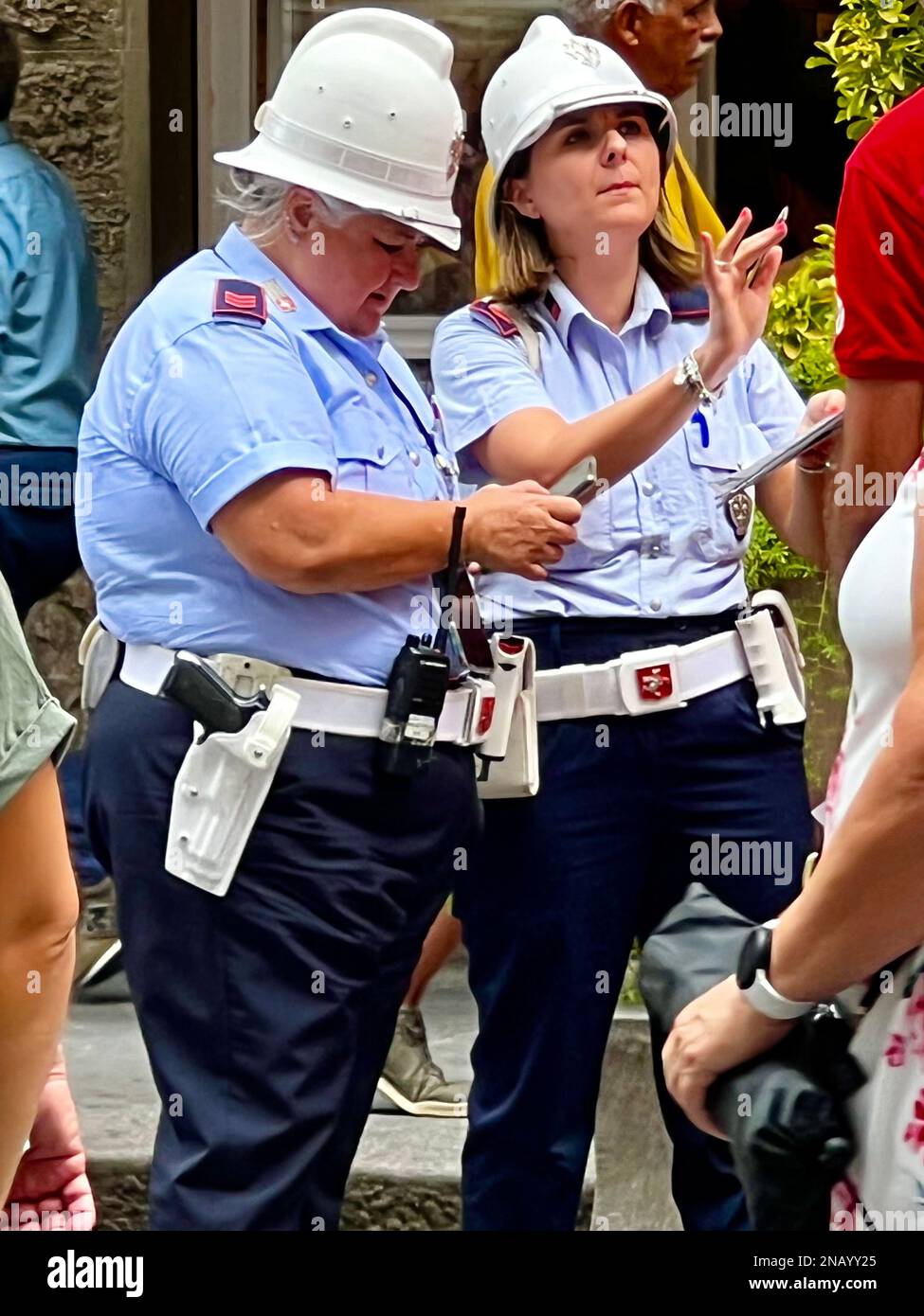 Zwei Polizisten der Stadtpolizei begegnen einem Touristen auf der Piazza della Duomo in Florenz, Italien Stockfoto