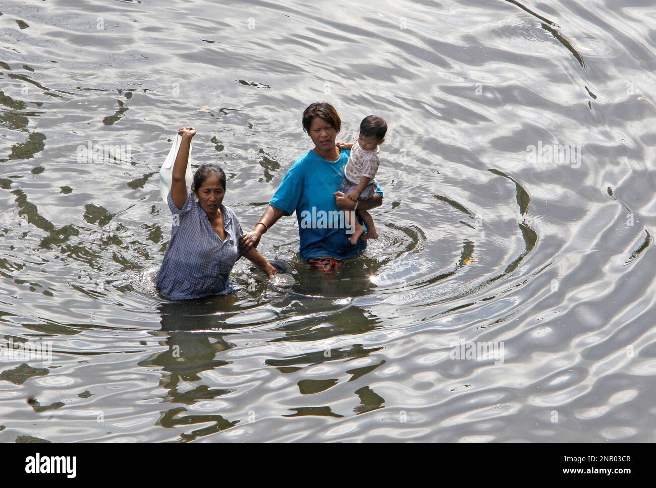 Bangkok residents wade through deep floodwaters in Bangkok, Thailand, Sunday, Oct. 30, 2011. Thailand's prime minister is expressing optimism that Thailand's worst flooding in a half-century will mostly spare Bangkok. (AP Photo/Sakchai Lalit) Stockfoto