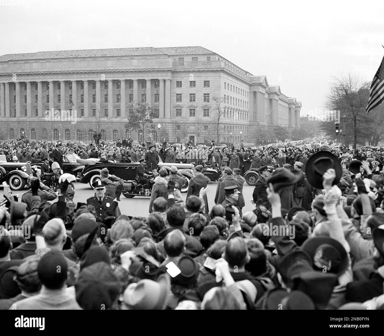 President Franklin D. Roosevelt, the only man ever to be named to a third term, received a thunderous reception from thousands of persons when he returned to Washington on Nov. 7, 1940, from his Hyde Park, N.Y., home. Riding with the president as the car approached the White House is Vice President-elect Henry A. Wallace; in front of them are Mrs. Eleanor Roosevelt, left, and Mrs. Wallace. Department of Commerce building is in background. (AP Photo) Stockfoto
