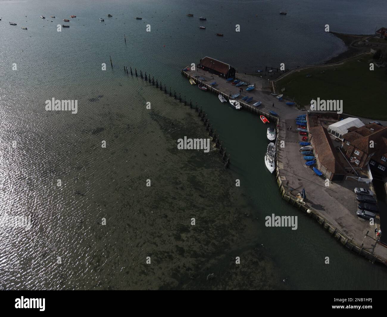 Bosham's Jetty und Boathouse mit dem Hafen und verschiedenen Booten, die ihn umgeben. Stockfoto