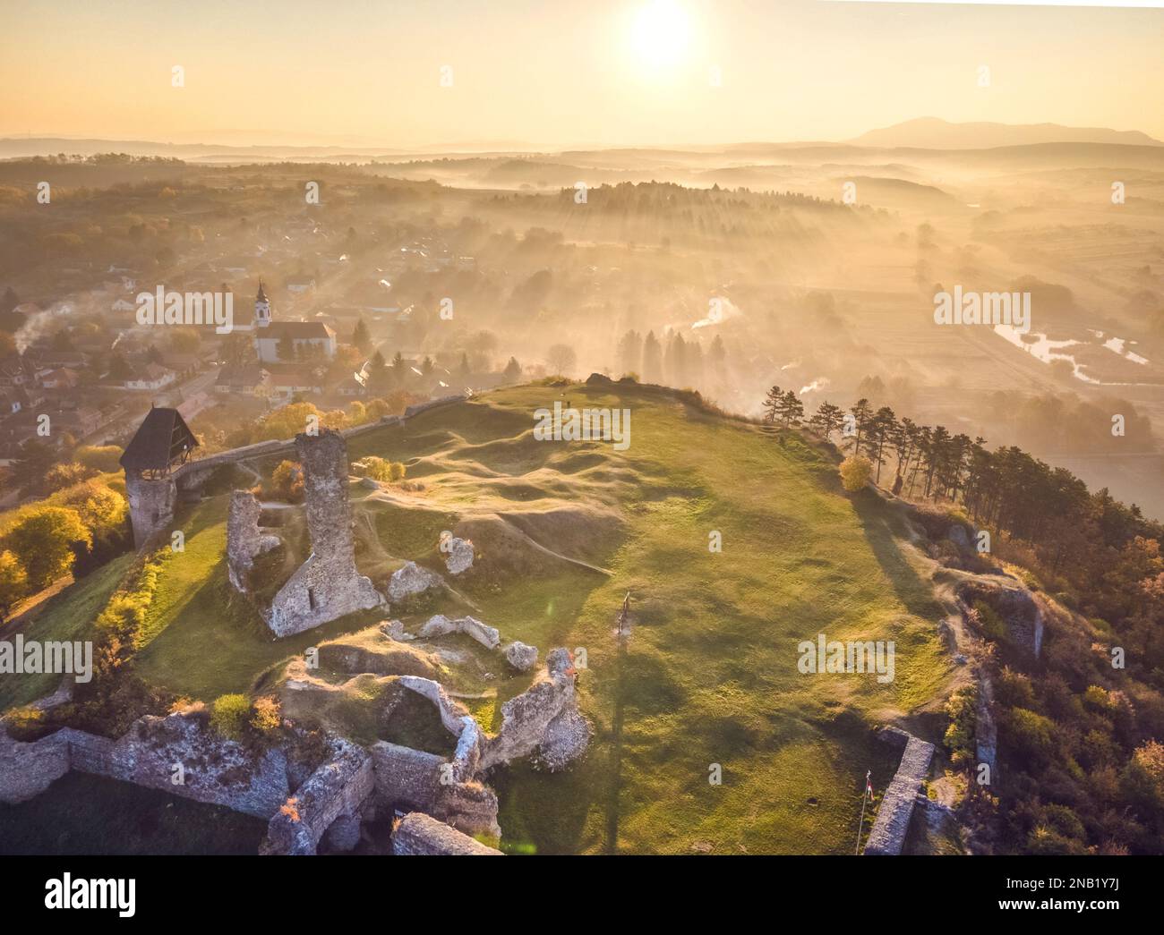 Luftaufnahme der Burg Nógrád mit den Lichtern eines wunderbaren Sonnenaufgangs im Herbst, Ungarn Stockfoto