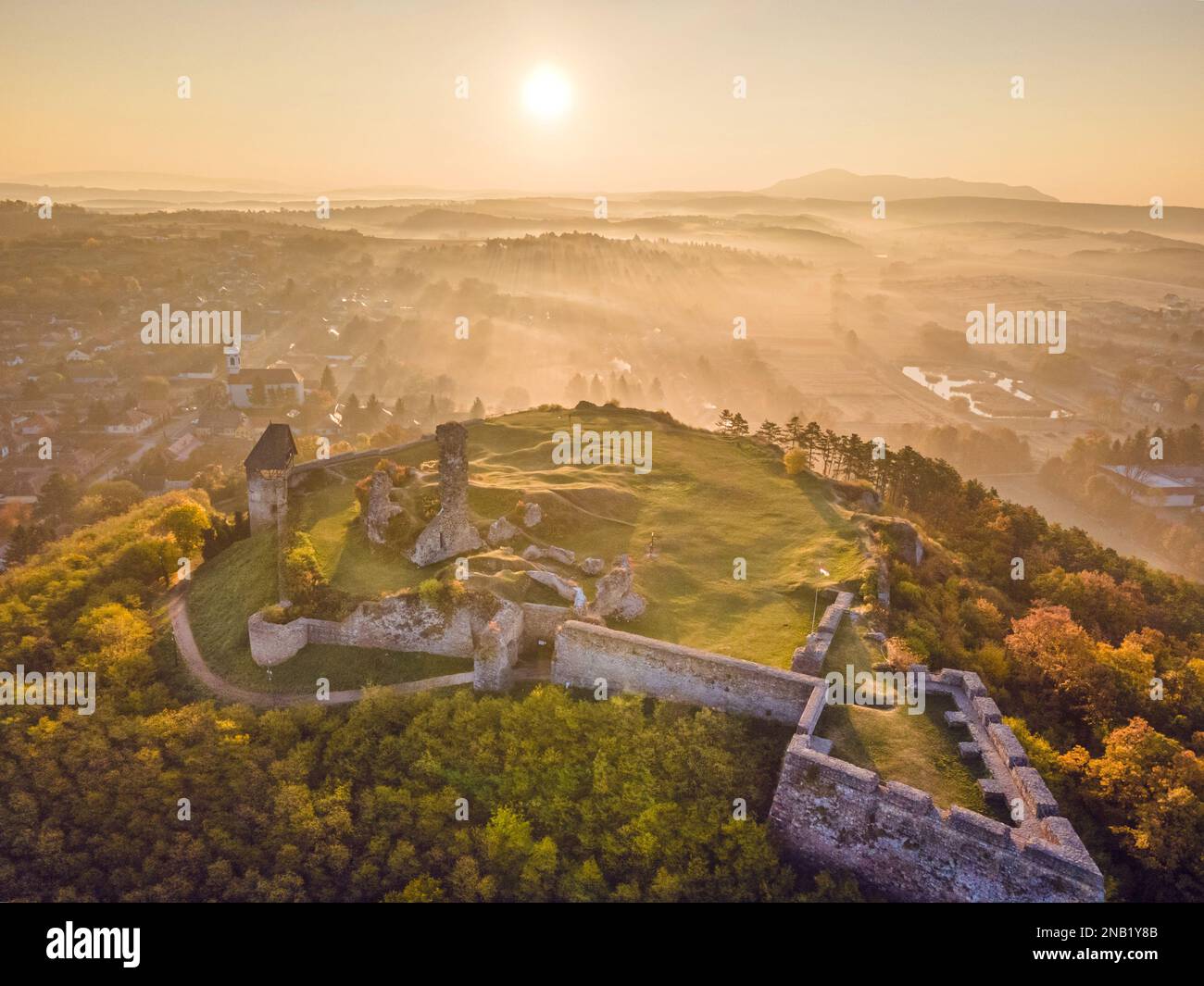 Luftaufnahme der Burg Nógrád mit den Lichtern eines wunderbaren Sonnenaufgangs im Herbst, Ungarn Stockfoto