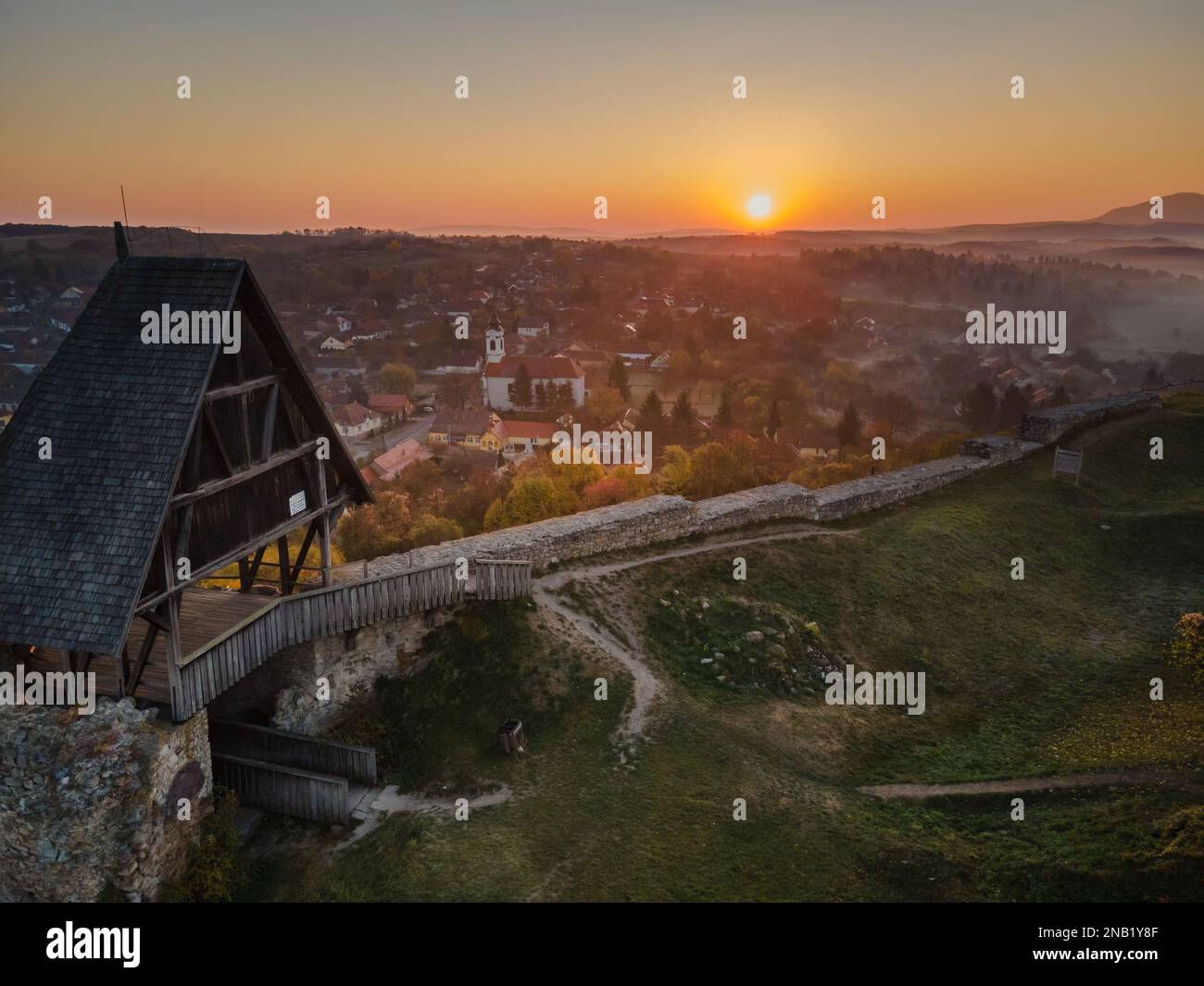 Luftaufnahme der Burg Nógrád mit den Lichtern eines wunderbaren Sonnenaufgangs im Herbst, Ungarn Stockfoto