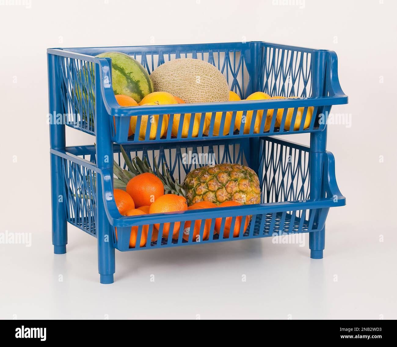Kunststofforganisator mit Früchten; Foto auf neutralem Hintergrund. Stockfoto