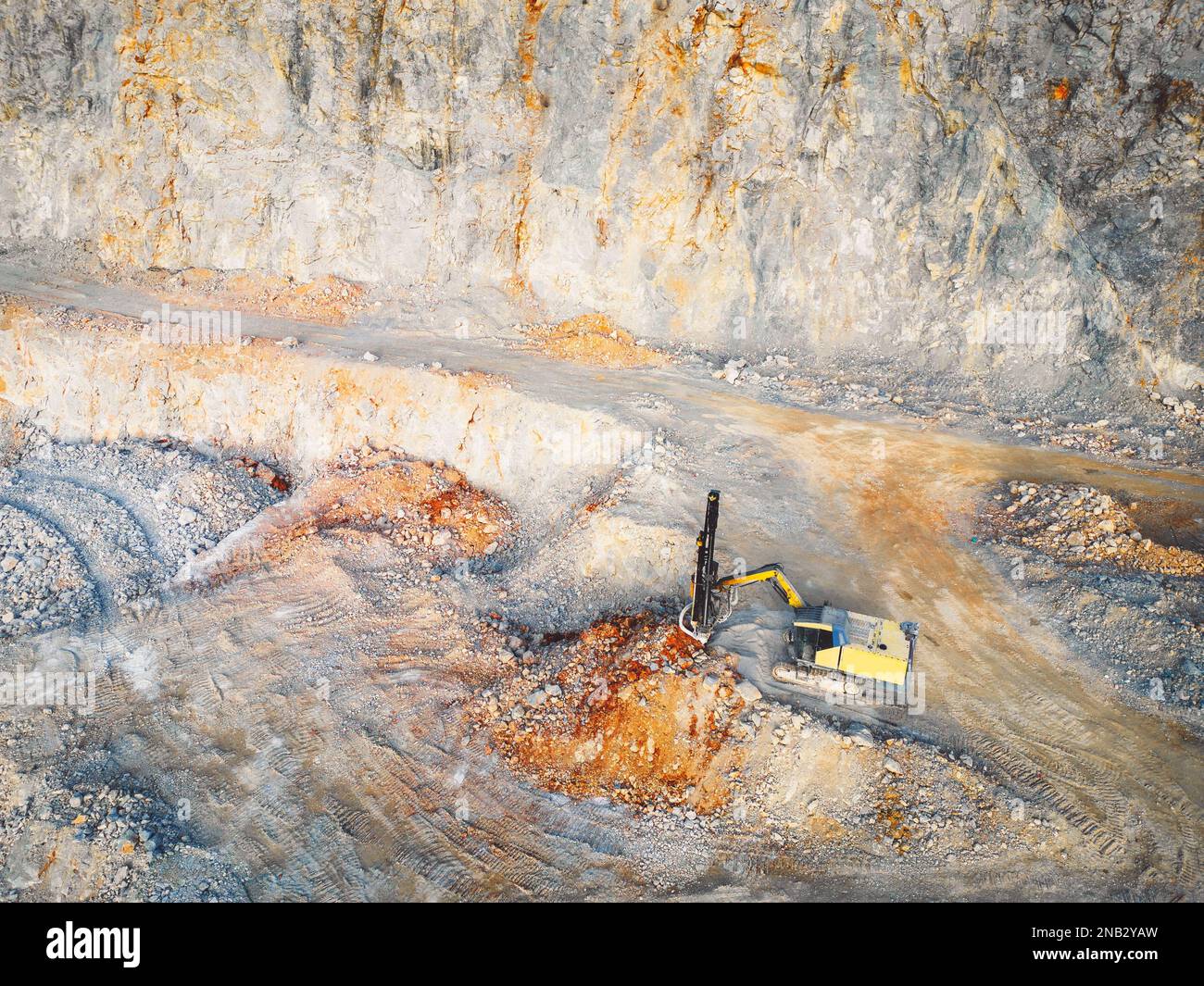 Bagger gräbt eine Grube im Steinbruch - kleiner offener Steinbruch Stockfoto