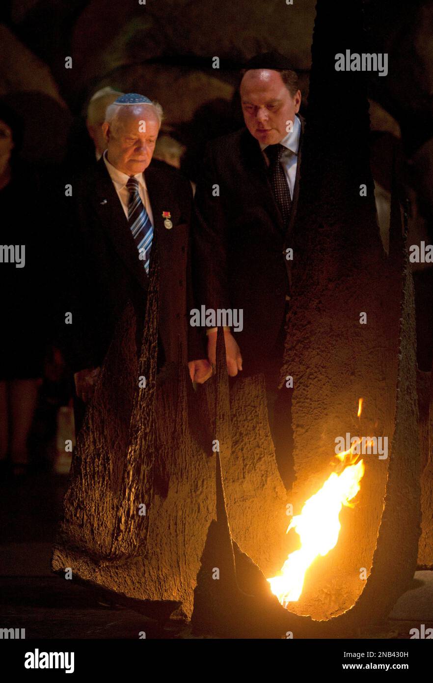 Michael Sidko, 76, left, one of the lone survivors of the Babi Yar massacre in which the Nazis gunned down 33,771 Jews over two days in 1941, rekindles the Eternal Flame during a ceremony marking 70 years since the massacre, at the Hall of Remembrance at the Yad Vashem Holocaust memorial, in Jerusalem, Thursday, Oct. 6, 2011. The Nazi invasion of the Soviet Union in June 1941 marked a turning point in the German plan to "solve the Jewish problem," with the establishment of the Einsatzgruppen paramilitary death squads. Babi Yar was one of the first mass killing sites.(AP Photo/Sebastian Scheine Stockfoto