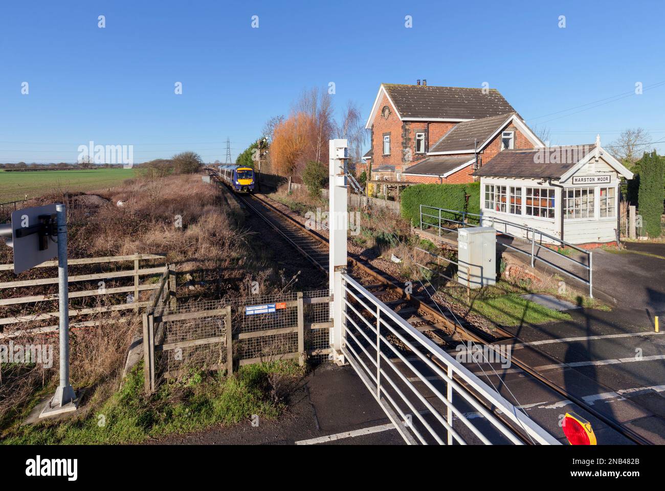 Der Turbostar-Zug der Northern Rail-Klasse 170 fährt an der kleinen mechanischen Signalbox vorbei und überquert die gezäunte Ebene am Marston Moor auf der Harrogate-Loop-Linie Stockfoto