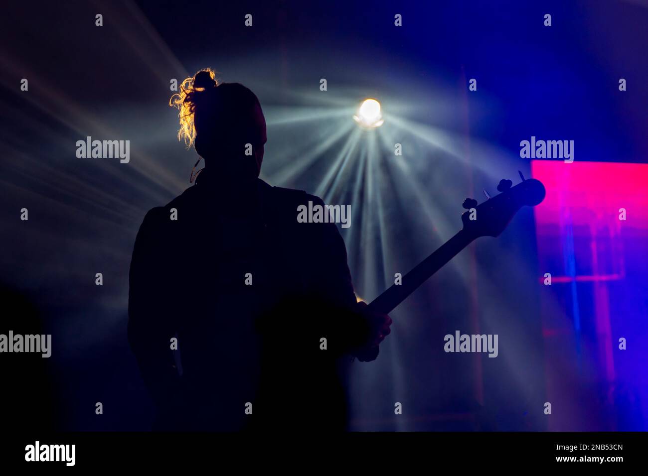 Die Silhouette des männlichen Gitarrenmanns im Hintergrund bei einem Konzert Stockfoto