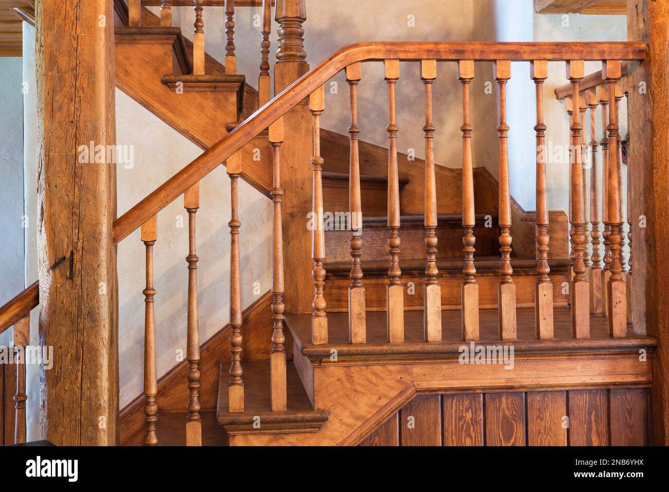 Kirschholztreppe führt in die obere Etage in ein altes 1826 Landhaus im Feldsteinhaus im Landhausstil. Stockfoto