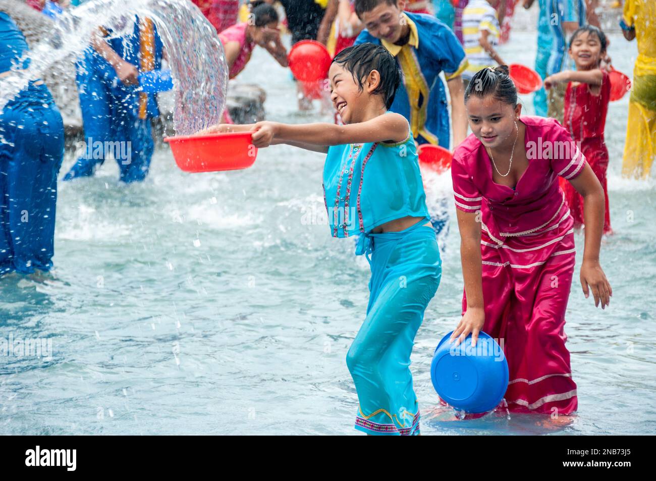 Mitglieder der ethnischen Gruppe der Dai-Minderheit feiern die neue jahrelange Reinigungstradition, sich in einem Wasserpark in Yunnan China mit Wasser zu bespritzen Stockfoto