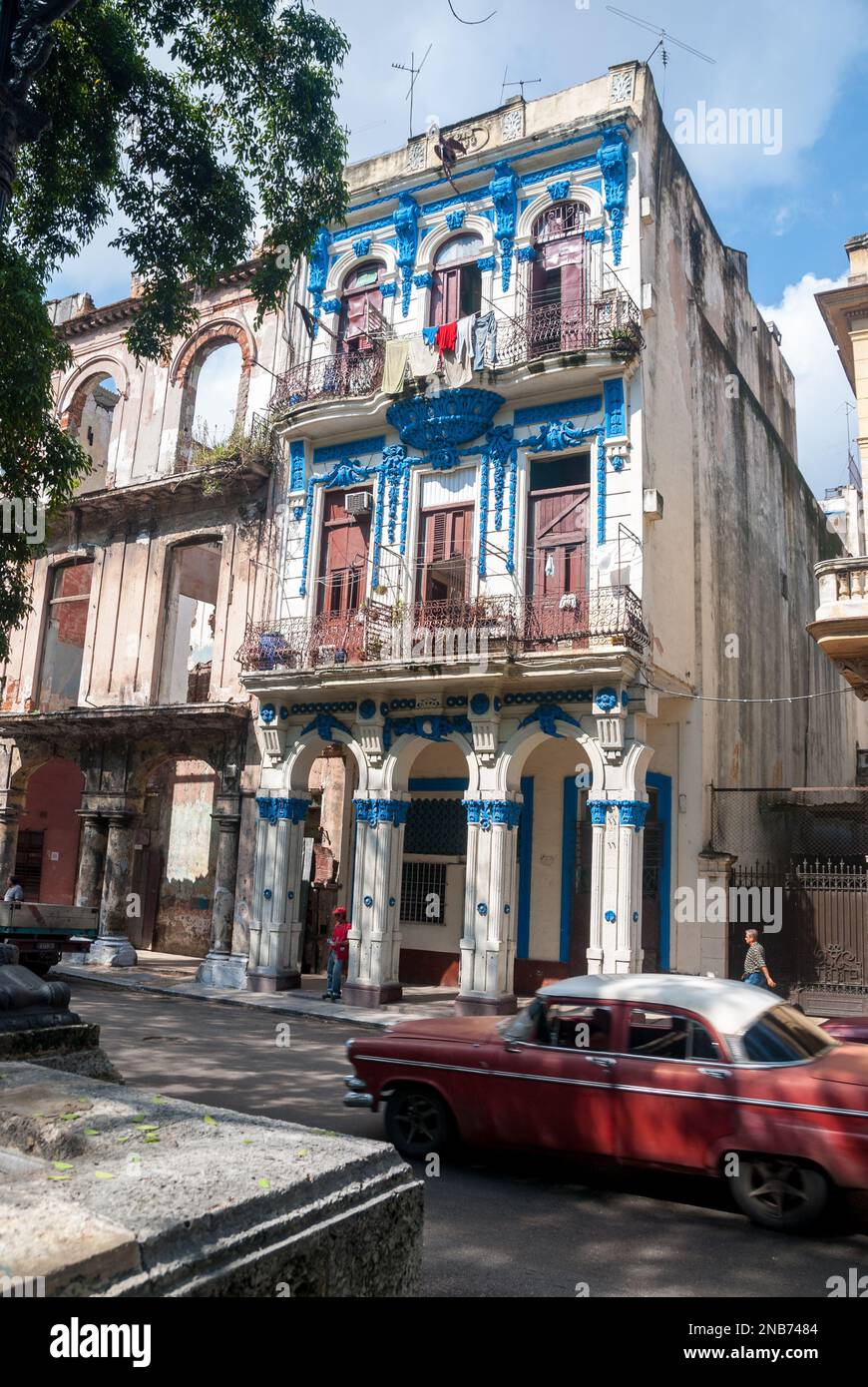 Ein Vintage American Automobil geht eines der vielen spanischen Kolonialstil inspirierte Gebäude auf dem Prado im Zentrum von Havanna Stockfoto