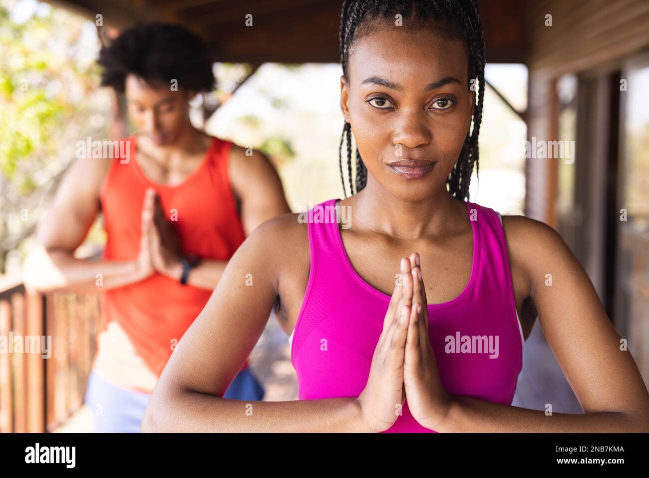 Portrait eines glücklichen afroamerikanischen Mannes, der Zeit in einer Blockhütte verbringt und Yoga praktiziert. Blockhütte, Natur- und Lifestyle-Konzept. Stockfoto