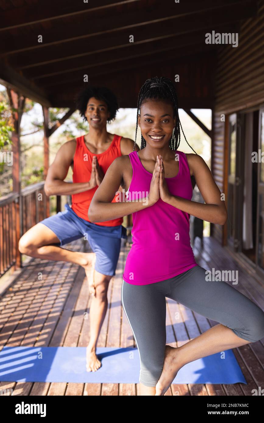 Portrait eines glücklichen afroamerikanischen Mannes, der Zeit in einer Blockhütte verbringt und Yoga praktiziert. Blockhütte, Natur- und Lifestyle-Konzept. Stockfoto