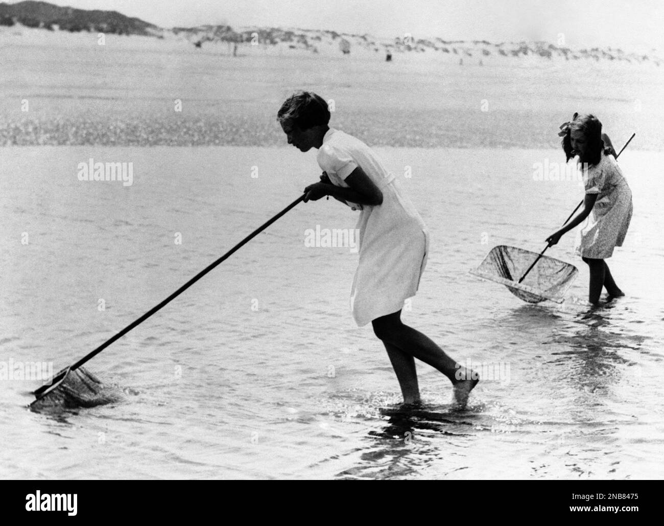 Princess Josephine Charlotte, 11 years old daughter of King Leopold of the Belgians, is now on holiday here at La Panne. She is staying in the royal palace occupied by the Belgian Royal family here during the war. Princess Josephine Charlotte, nearest, enjoying a shrimping expedition at La Panne, Belgium, on June 24, 1938. (AP Photo) Stockfoto
