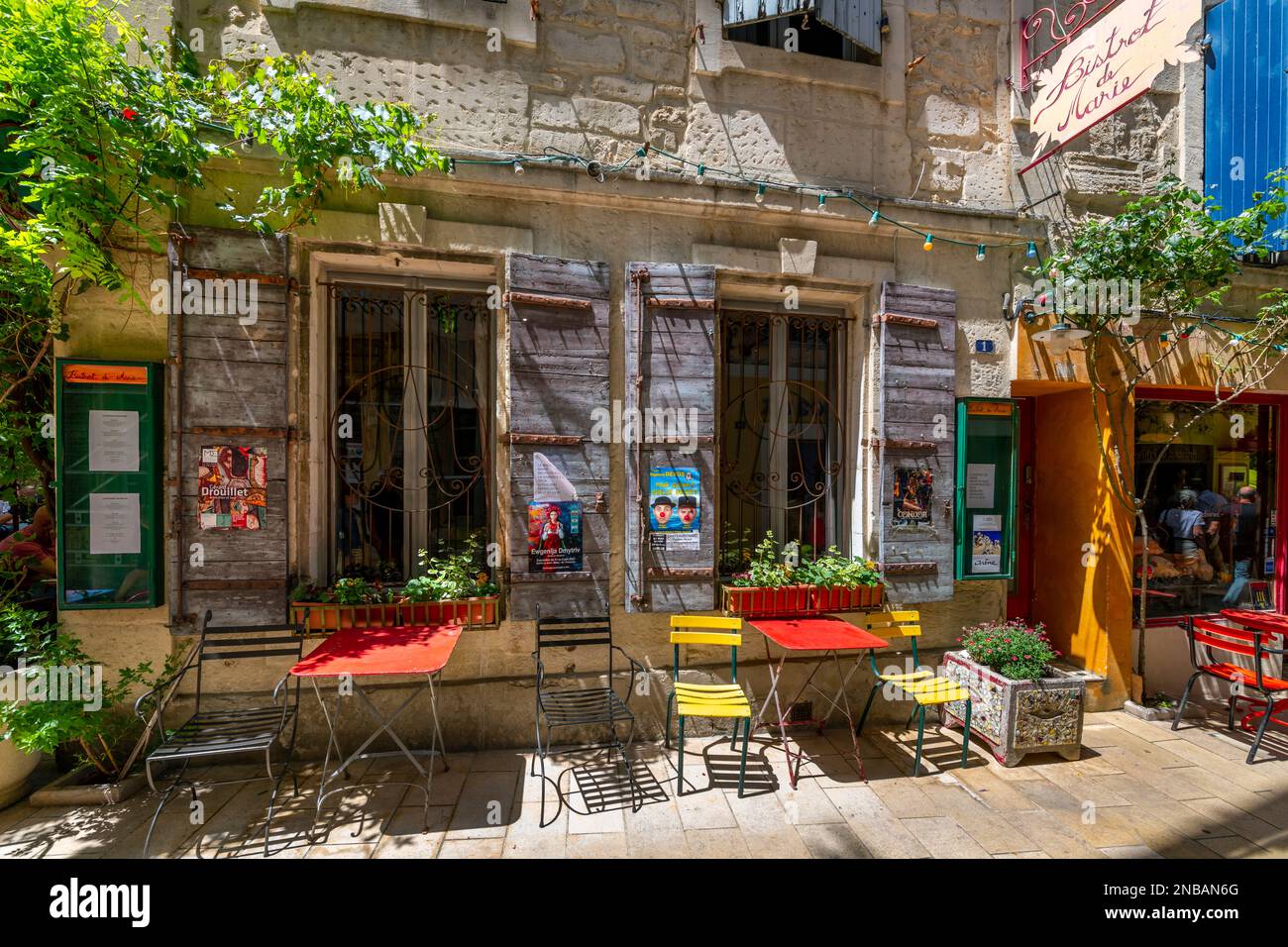 Allgemeiner Blick auf die Fassade, Schilder und Tische im Freien im Café Bistrot de Marie im historischen Dorf Saint-Remy, Frankreich. Stockfoto