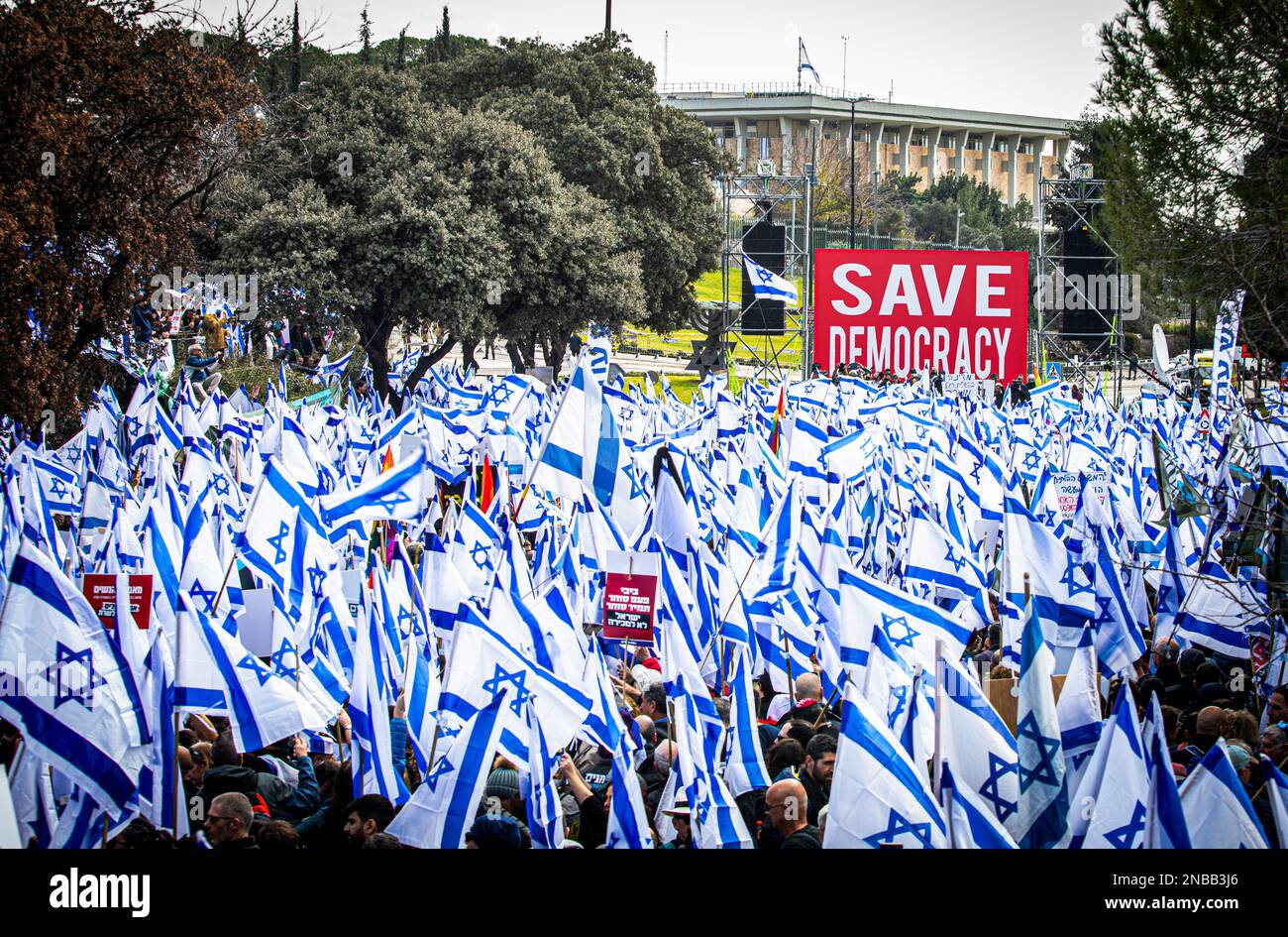 Jerusalem, Israel. 13. Februar 2023. Während der Demonstration winken Demonstranten Flaggen und halten Plakate. Zehntausende von Israelis, die mit Flaggen wedelten, haben sich gegen das israelische parlament der Knesset in Jerusalem versammelt, um gegen den Plan von Ministerpräsident Benjamin Netanjahu zu protestieren, die Justiz zu schwächen und das Land in einen sozialen Zusammenbruch zu stürzen. (Foto: Eyal Warshavsky/SOPA Images/Sipa USA) Guthaben: SIPA USA/Alamy Live News Stockfoto