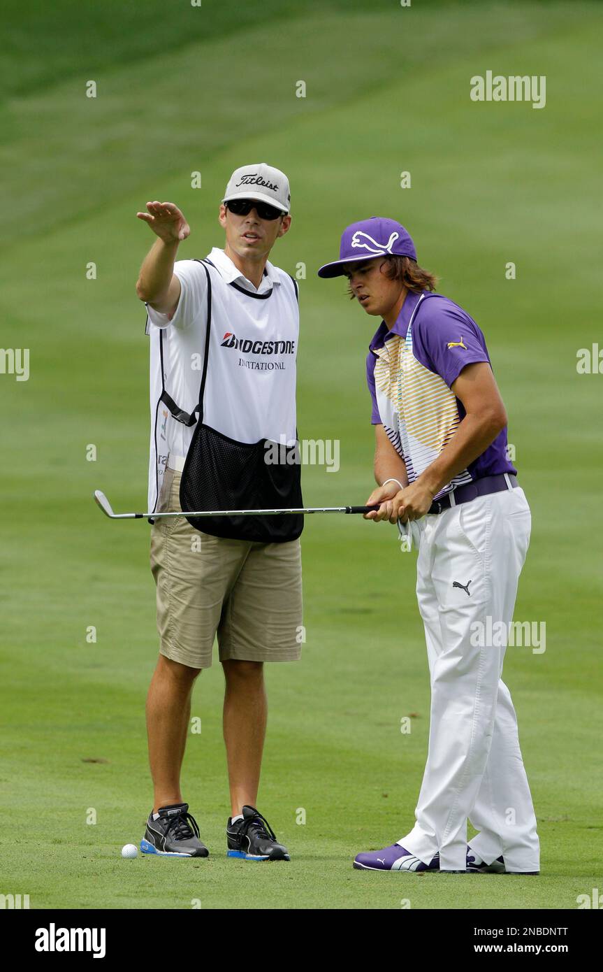 Caddie Joe Scovron, left, talks with Rickie Fowler about a shot during the first round of the Bridgestone Invitational golf tournament at Firestone Country Club in Akron, Ohio Thursday, Aug. 4, 2011. (AP Photo/Mark Duncan) Stockfoto