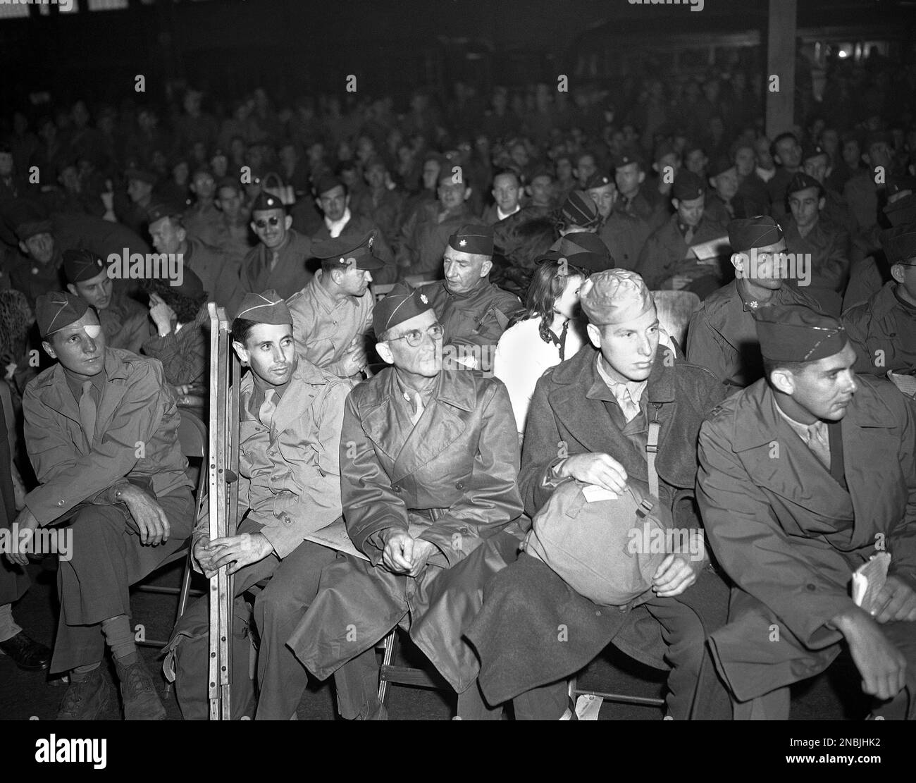 Recently freed prisoners from the camps in the Philippines sit on the dock, listening to Eddie Cantor after arriving in San Francisco, Calif., March 16, 1945. (AP Photo/Jack Rice) Stockfoto