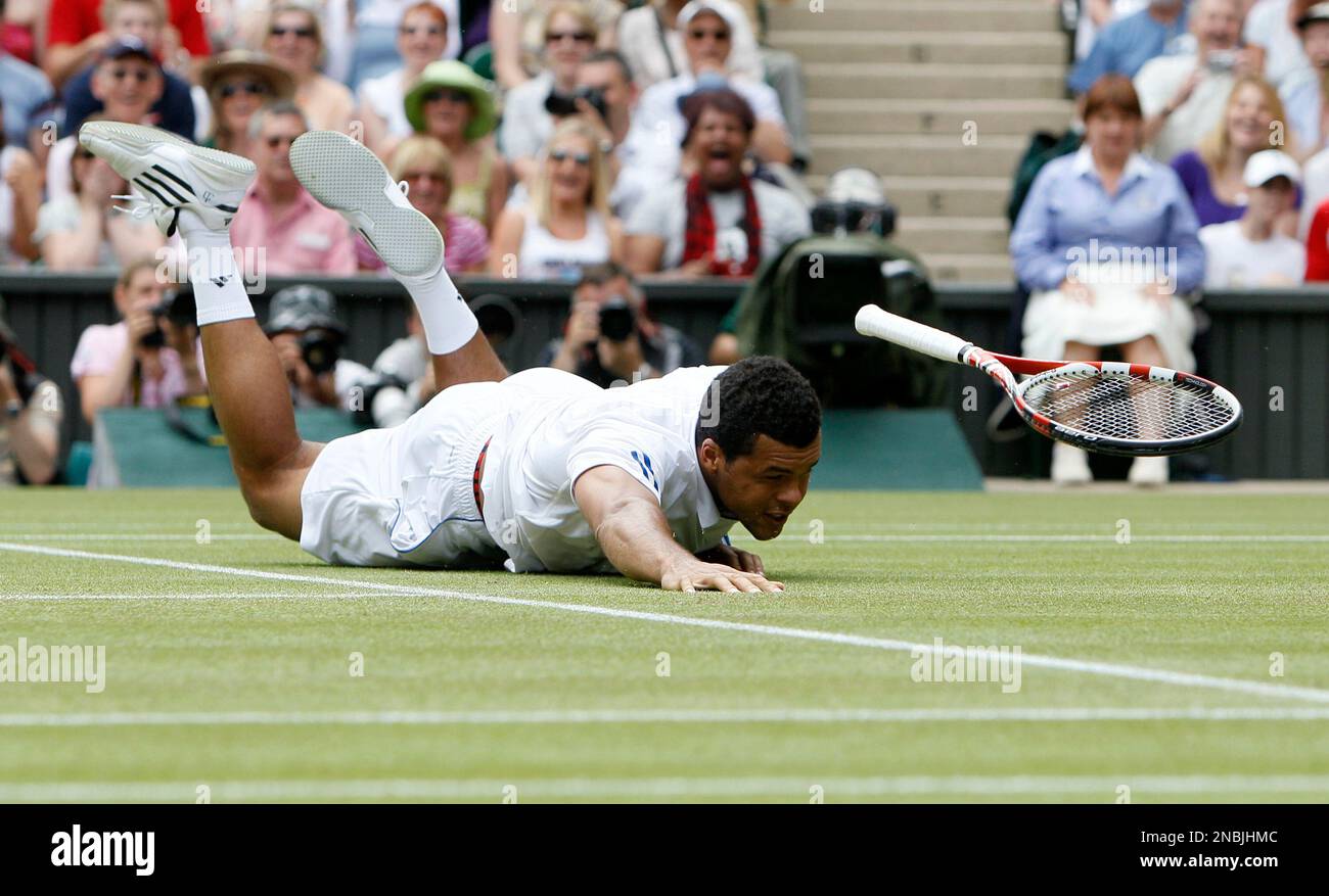 France's Jo-Wilfried Tsonga lays on the court after diving for a shot during his match against Switzerland's Roger Federer at the All England Lawn Tennis Championships at Wimbledon, Wednesday, June 29, 2011. (AP Photo/Alastair Grant) Stockfoto