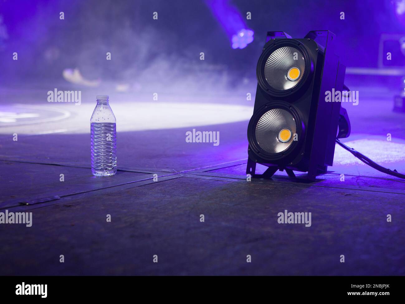 Eine Flasche Wasser über der Bühne neben dem Lichtblinder. Selektiver Fokus Stockfoto