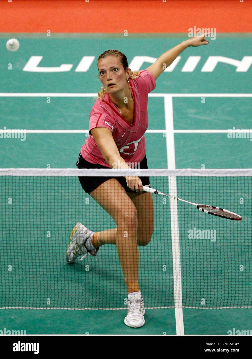 Tine Baun of Denmark returns a shot to Wang Xin of China during their