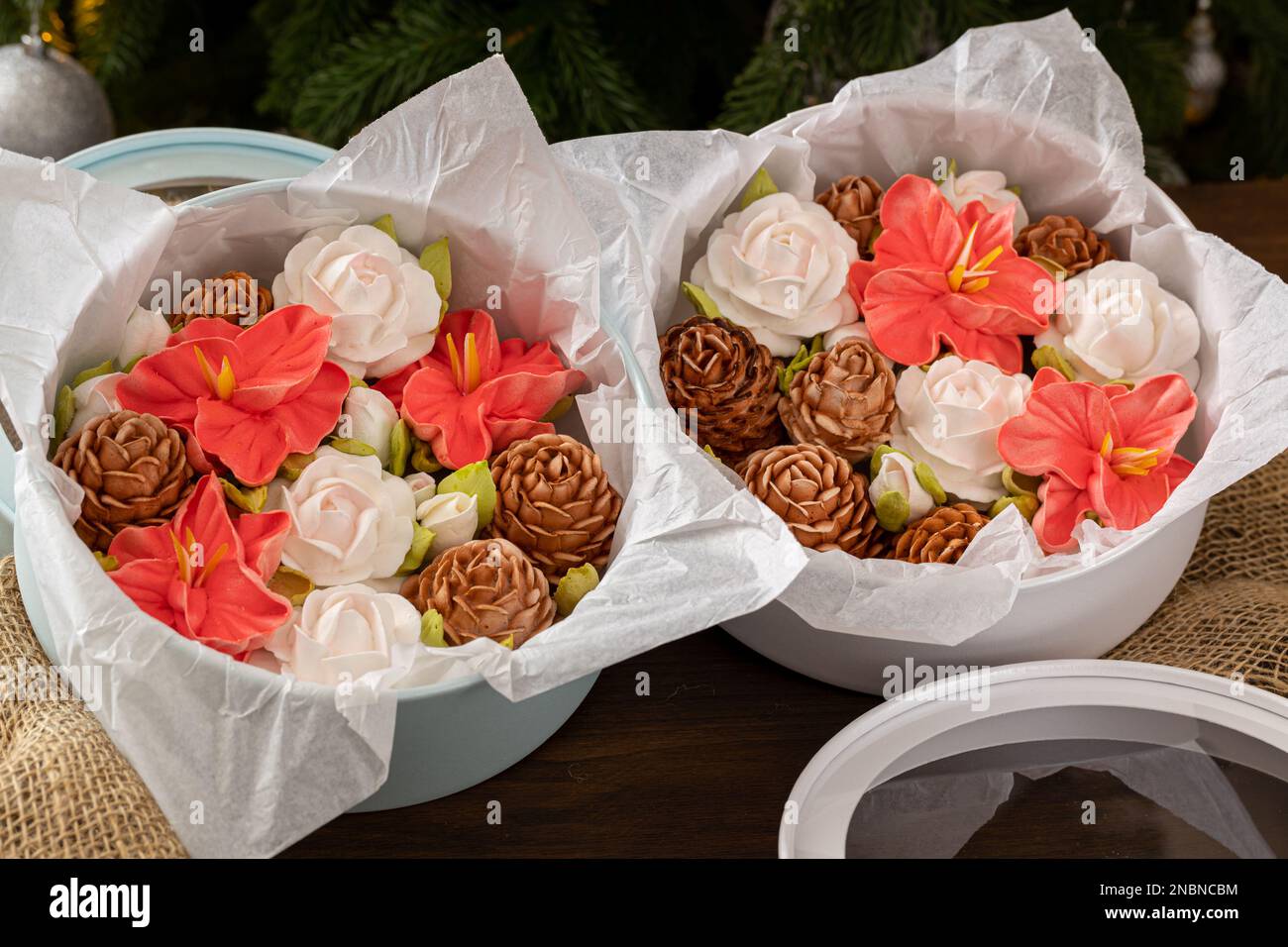 Marshmallow-Blumenstrauß in einer Geschenkbox auf dem Hintergrund eines Weihnachtsbaums, das Konzept einer festlichen Stimmung. Stockfoto