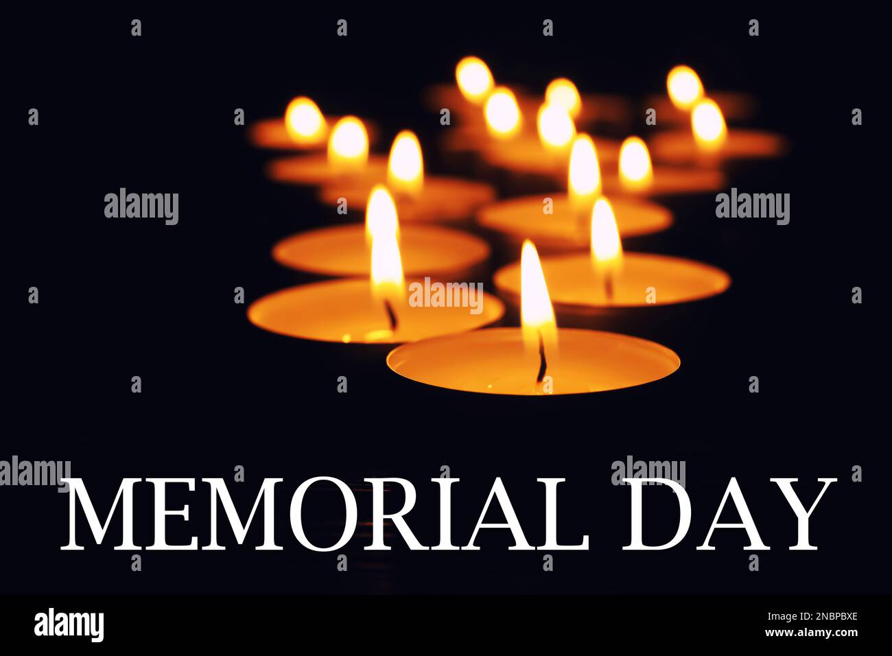Gedenktag. Wachskerzen brennen auf schwarzem Hintergrund Stockfoto
