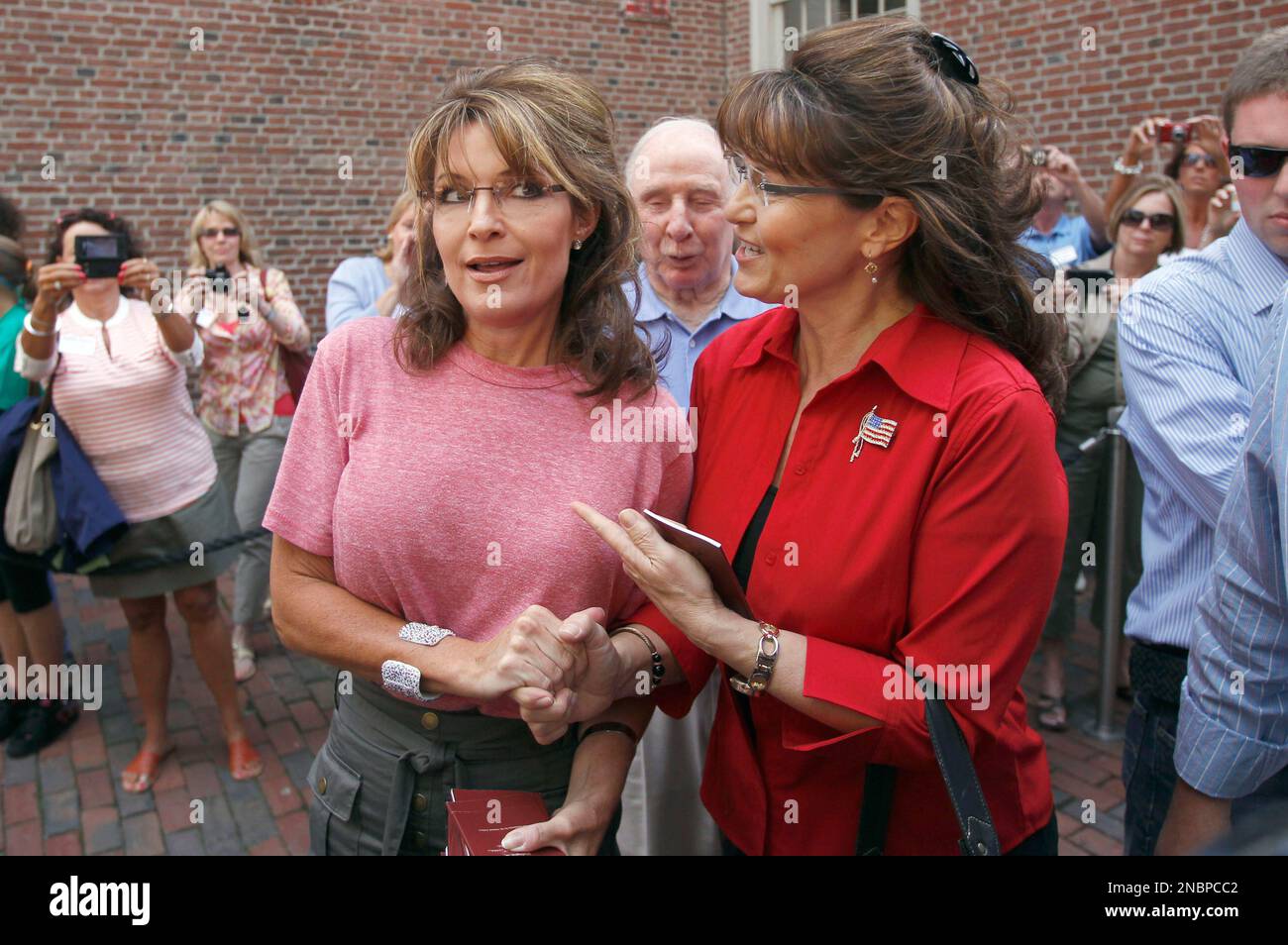 Former Alaska Gov. Sarah Palin, left, poses with celebrity look-alike impersonator Cecilia Thompson during a tour of Boston's North End neighborhood, Thursday, June 2, 2011. Palin's father Chuck Heath is at center. (AP Photo/Steven Senne) Stockfoto