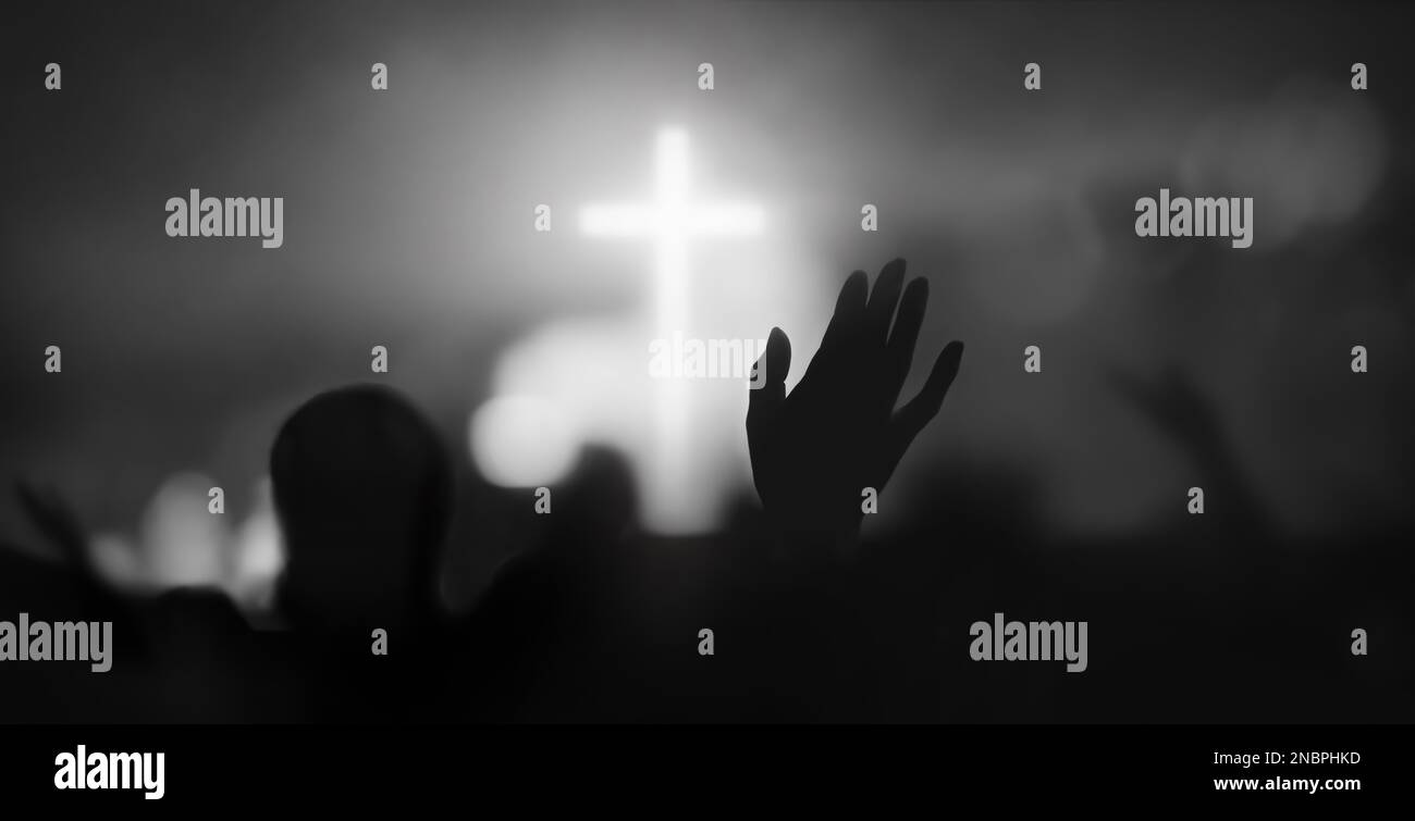 Leidenschaftliches christliches Lob mit erhobenen Händen zum Kreuz und Heiliger Geist füllte die liebenswürdige Kirchenverehrung mit Bokeh und Silhouette Hintergrund Stockfoto