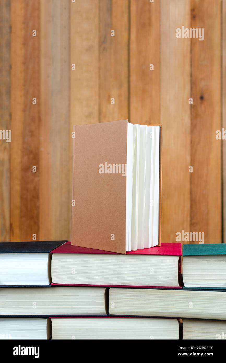Geschlossenes Buch auf einem Stapel Bücher in Form einer Wand Stockfoto
