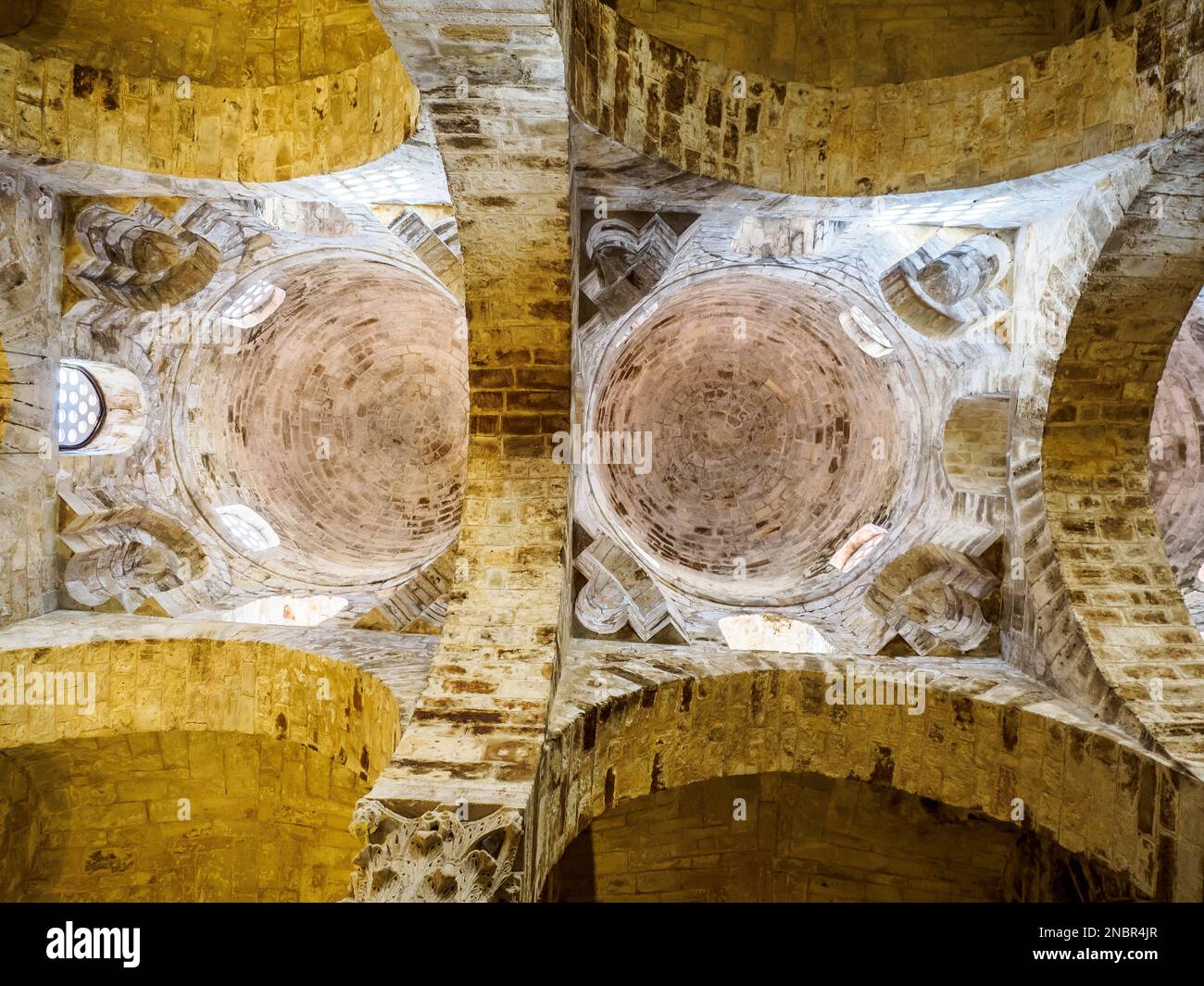 Zentrales Schiff, erhabene halbkuppelförmige Kuppeln, die auf Trommeln liegen, gestützt von Säulen. Die mit konzentrischen Ringen in Sandsteinaschern gebauten Kappen in der arabisch-normannischen Architekturkirche San Cataldo - Palermo, Sizilien, Italien Stockfoto