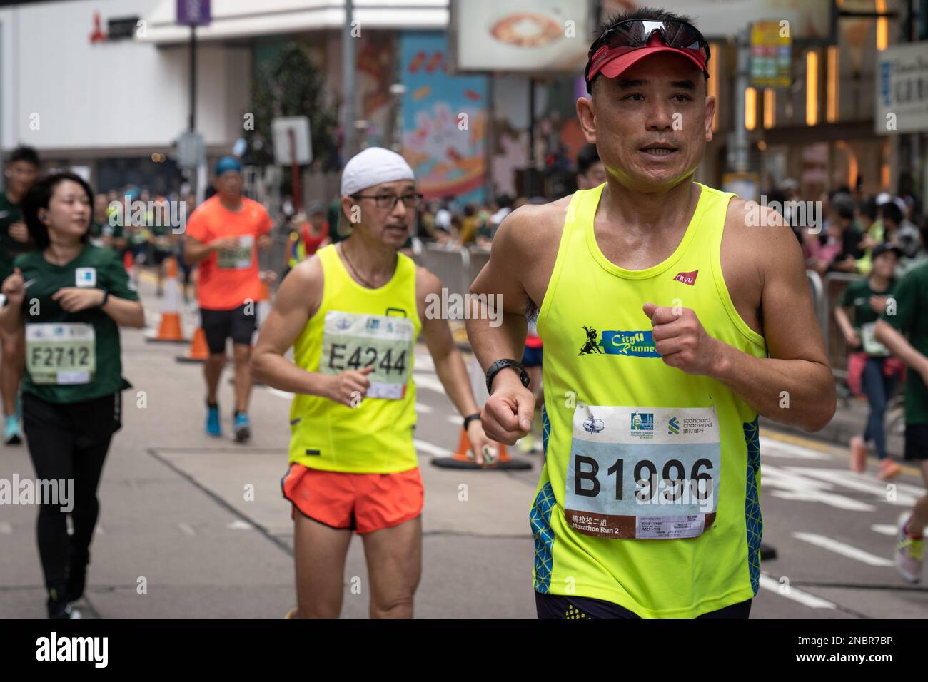 Hongkong, China. 12. Februar 2023. Läufer, die die letzte Etappe im Rennen beendet haben. Hong Kong Standard Chartered Marathon kehrt zurück, als über 30.000 Läufer an einem nebligen Tag dem feuchten Wetter trotzten. Der jährliche Wettbewerb wurde für etwa ein Jahr ausgesetzt, nachdem die Stadt durch die covid-Einschränkung eingeschränkt wurde. Obwohl die Stadt ihre sozialen Distanzmaßnahmen langsam lockert, müssen Läufer vor und nach dem Rennen Masken tragen. (Foto: Ashley Chan/SOPA Images/Sipa USA) Guthaben: SIPA USA/Alamy Live News Stockfoto