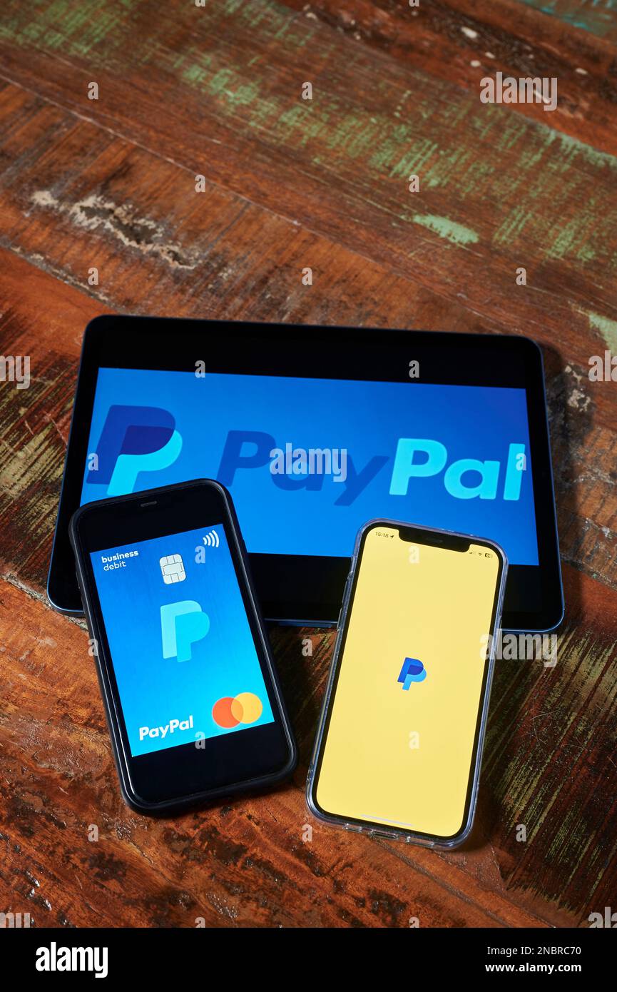 Berlin - 23. Januar 2023: Drei Mobilgeräte mit dem Startbildschirm eines internationalen Zahlungsdienstleisters. Stockfoto