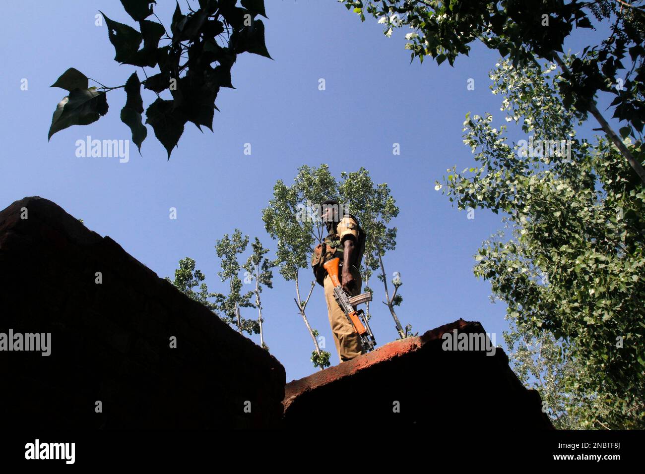 A paramilitary soldier stands guard outside a polling station during voting for village panchayat (local civil body) elections, on the outskirts of Srinagar, India, Monday, May 16, 2011. (AP Photo/Mukhtar Khan) Stockfoto