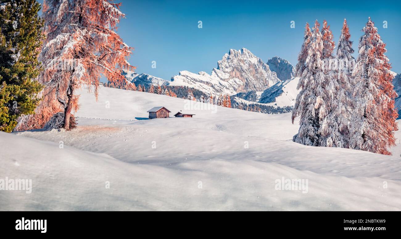 Unberührte Winterlandschaft. Atemberaubender Blick am Morgen auf das Dorf Alpe di Siusi mit dem Seceda-Gipfel im Hintergrund. Herrliche Winterszene der Dolomiten-Alpen, Iity Stockfoto