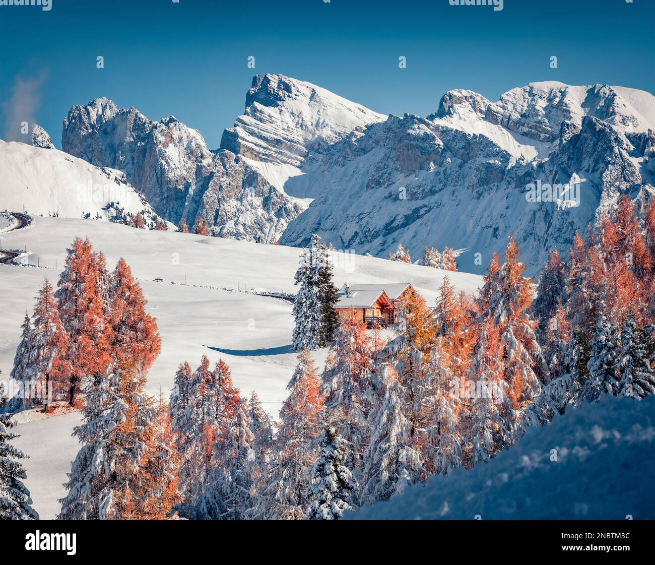 Zwei hölzerne Chalets im Bergtal. Fantastischer Blick am Morgen auf das Dorf Alpe di Siusi mit dem Furchetta-Gipfel im Hintergrund. Atemberaubende Winterszene von Dolom Stockfoto