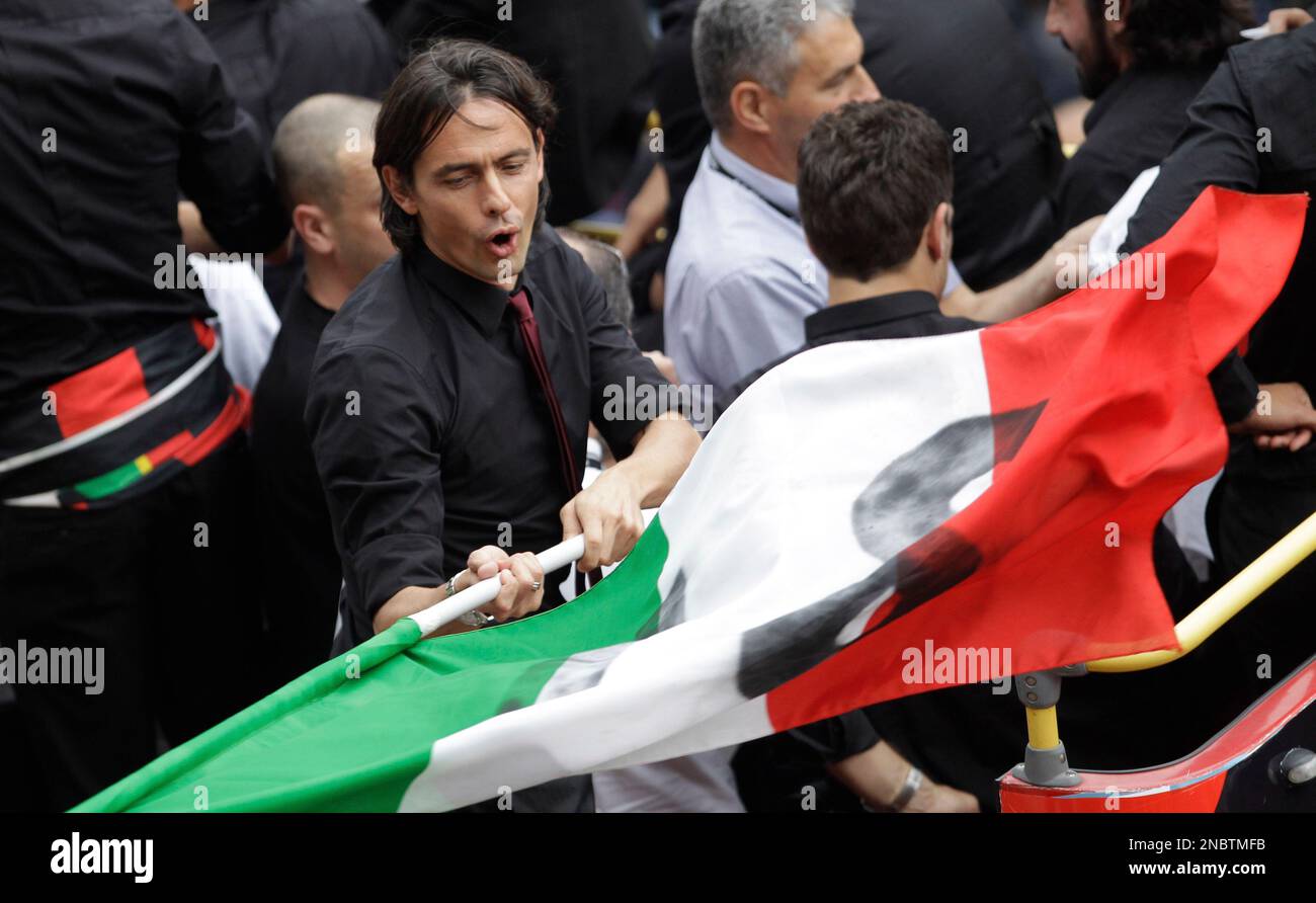 AC Milan striker Filippo Inzaghi waves an Italian flag as he stands on a bus carrying the triumphant AC Milan soccer team players celebrating their 18th Italian Serie A top league title, in Milan, Italy, Saturday, May 14, 2011. AC Milan ended five years of dominance by city rival Inter Milan last Saturday, clinching its first Serie A title since 2004. (AP Photo/Luca Bruno) Stockfoto
