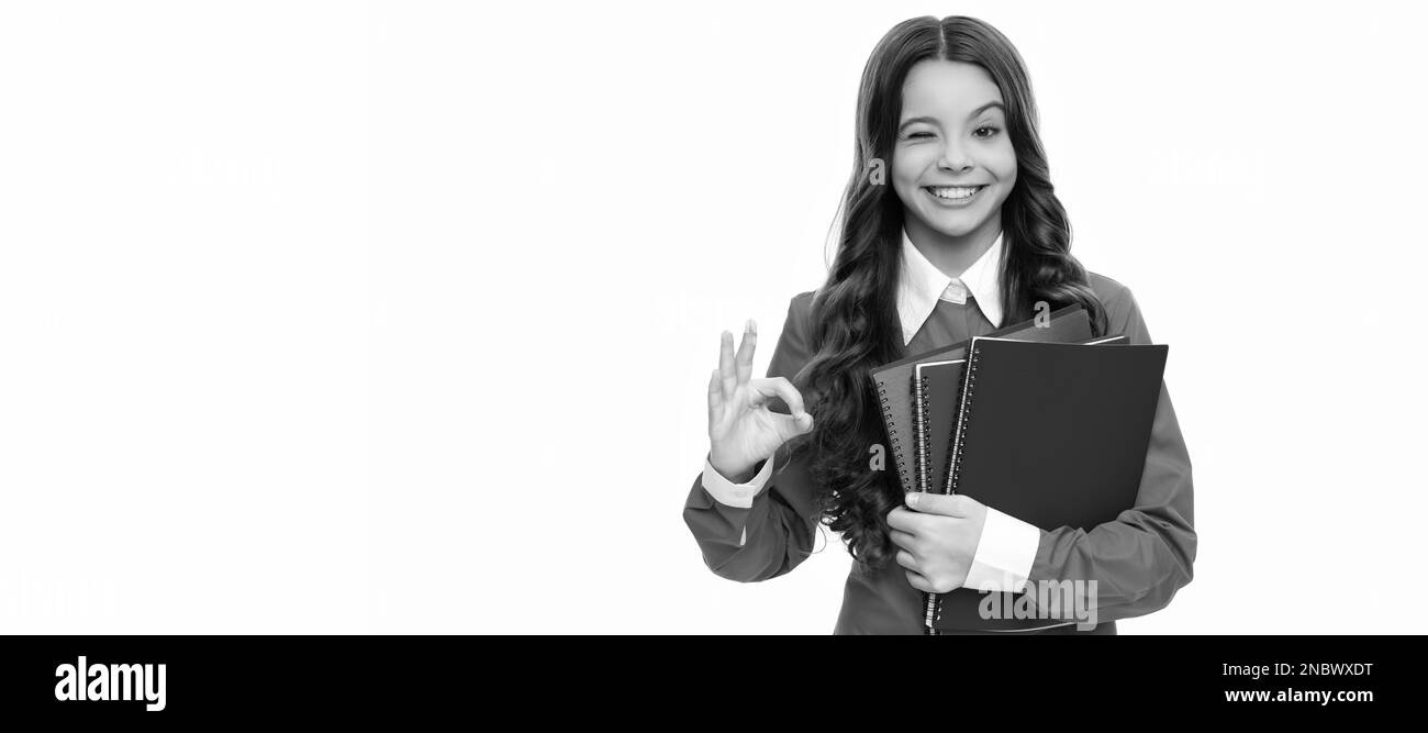 Winken Kind lange lockiges Haar halten Schule Arbeitsbuch isoliert auf weiß zeigen ok Geste, High School. Banner der Schülerin. Schüler der Schule Stockfoto