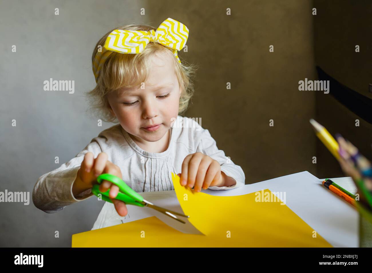Kinder machen Hausaufgaben. Das Kind stellt Anwendungen aus farbigem Papier. Schulprojekt für Kinder. Stockfoto
