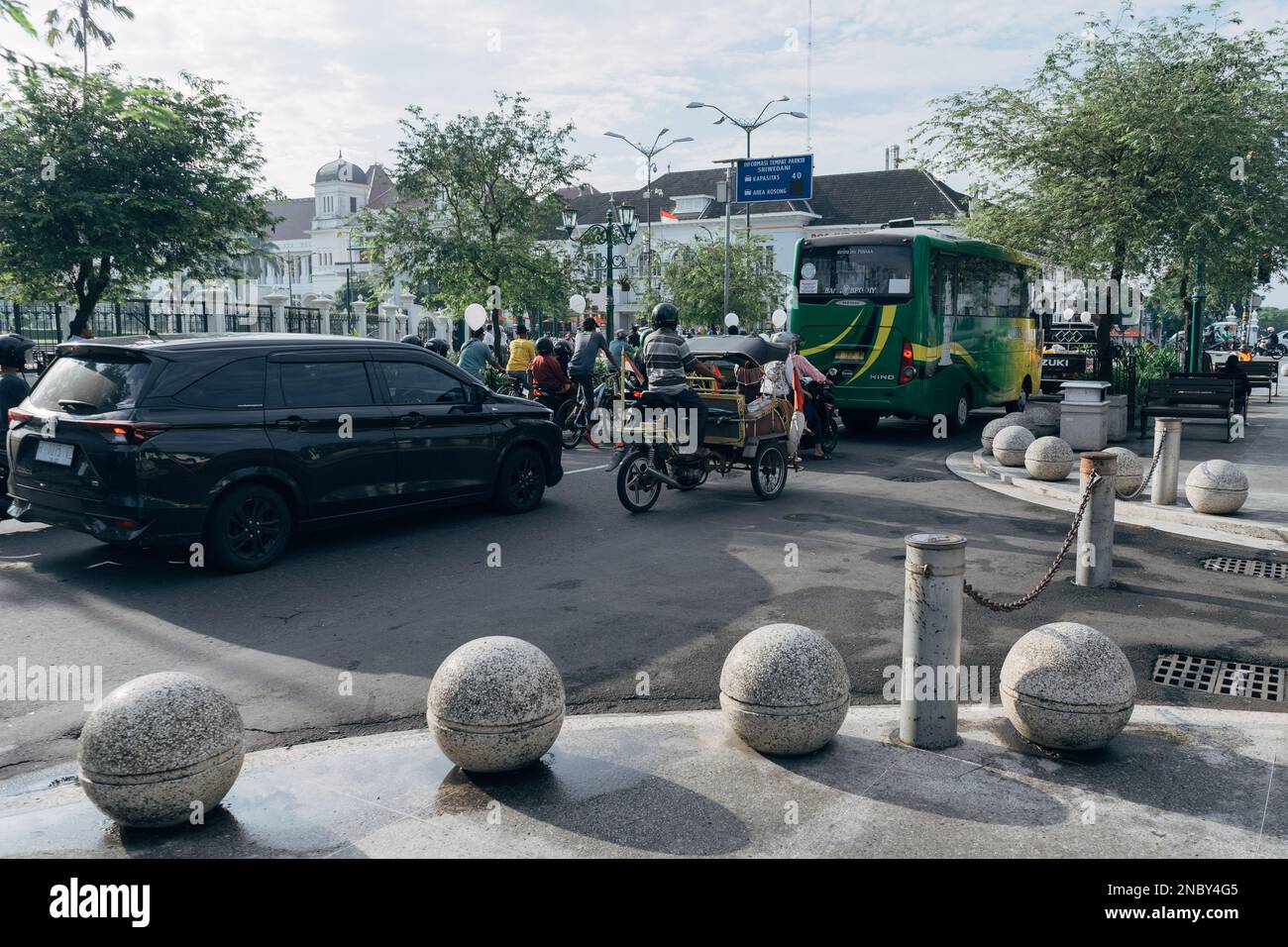Yogyakarta, Indonesien - ca. 2023: Einwohner fahren mit verschiedenen Fahrzeugen, die an der Ampel in km 0 halten. Point Jogja in der Nähe der Malioboro Straße. Stockfoto